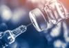 Deadly Outbreak Spurs Emergency Shot Blitz syringe needle drawing liquid from a vaccine vial