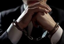 Road-Rage Tirade Engulfs House Hopeful Businessperson in handcuffs with hands clasped