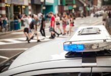Rugby Send-Off Turns Horror police car roof light bar with blue lights near a busy crosswalk