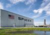 Musk’s Roadster FLIES – Then Rival Claps Back SpaceX hangar beside launch pad under blue sky