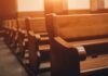 Report Details Abuse Across Three Dioceses Wooden church pews in warm sunlight