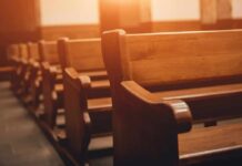Report Details Abuse Across Three Dioceses Wooden church pews in warm sunlight