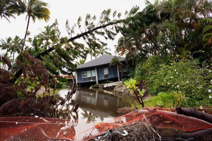 shutterstock_1279515805 house by flooded canal with fallen palm trees