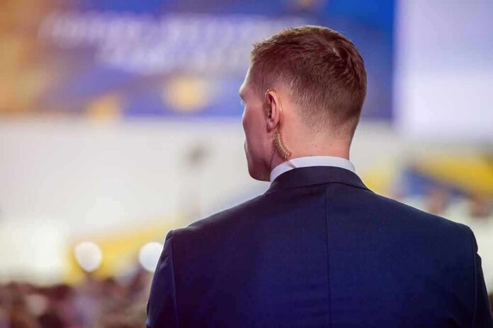 shutterstock_1299240973 Man in suit with earpiece at event