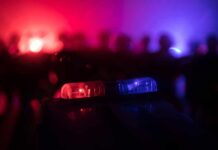 Downtown Blast Stuns Food Titan Police car light bar flashing red and blue at night