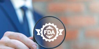 Magnifying glass held by person in suit showing FDA badge icon