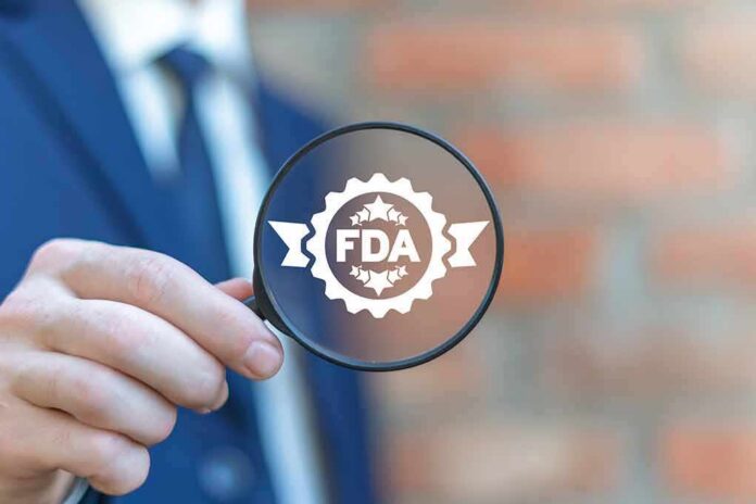 shutterstock_1599868912 Magnifying glass held by person in suit showing FDA badge icon