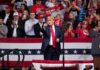 Midterm Power Play – Trump Storms Kentucky Donald Trump points from a rally stage; Rudi Koertzen and Bear Pascoe are in the crowd