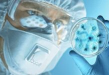 Mystery Pneumonia Triggers Mass Quarantine Scientist in protective gear examining a petri dish
