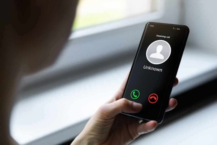 shutterstock_1688340721 Person holding smartphone with unknown caller screen