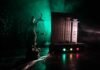 Lady Justice statue beside medical syringes with moody green light