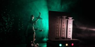 Lady Justice statue beside medical syringes with moody green light