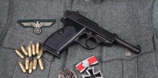 Pistol on military jacket with ammunition and medals