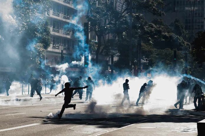Protesters running through tear gas on a city street