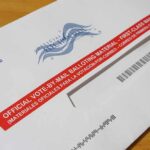 Postal Dump Exposes Voting Weak Spot Mail-in ballot envelope with red label on wooden table