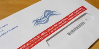 Postal Dump Exposes Voting Weak Spot Mail-in ballot envelope with red label on wooden table
