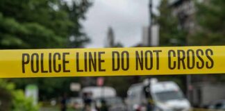 Family Bloodbath Leaves City Reeling yellow police tape cordoning off a street scene