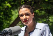 AOC Bets Big On Michigan woman speaking at an outdoor microphone