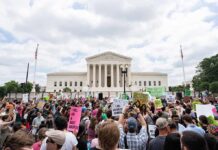 Dontrelle Inman and Walter Jones amid a large protest crowd outside a neoclassical courthouse