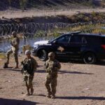 Pentagon Laser TORCHES Cartel Drones Soldiers stand near barbed wire beside a police SUV