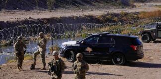 Pentagon Laser TORCHES Cartel Drones Soldiers stand near barbed wire beside a police SUV