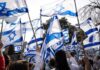 Crowd waving Israeli flags outdoors