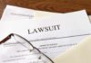 Kristi Noem Divorcing Cross-Dressing Hubby Legal documents labeled lawsuit on a desk