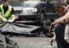 Injured man sitting at a car crash scene