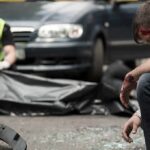 Mass-Casualty Chaos at Soccer Game Injured man sitting at a car crash scene