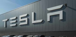 AI Hype Meets Budget Brake at Tesla Tesla cars parked outside a large Tesla building