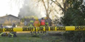 Grim Burns After Explosive Miami Dispute Yellow police tape marking a restricted area at a fire scene with firefighters in the background