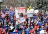 Tim Teufel, Christian Jones, and Nash the Slash among a crowd at a political rally holding signs and flags