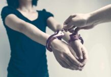 Houston Custody Clash Ends In Blood Person being handcuffed with hands extended forward